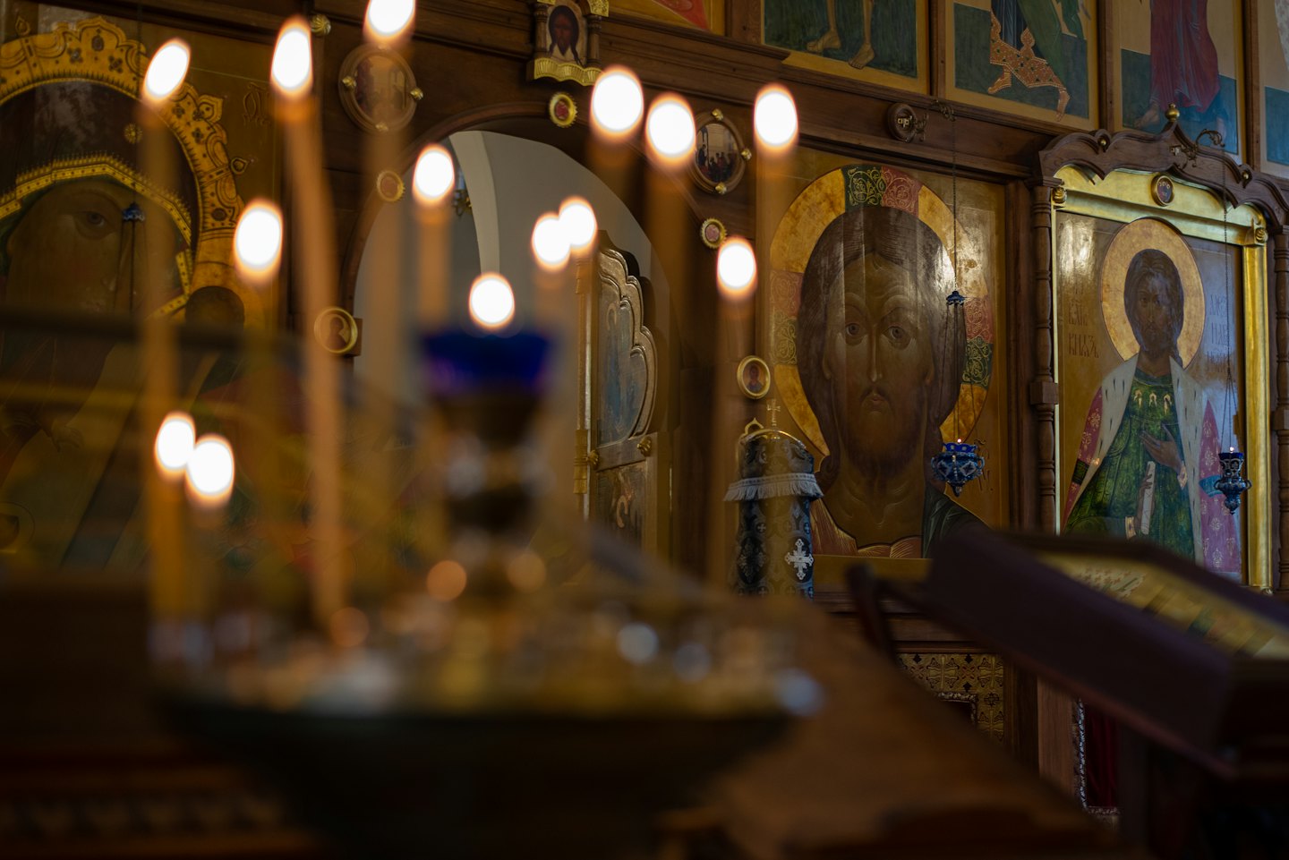Lit candles in front of Eastern Orthodox icons.