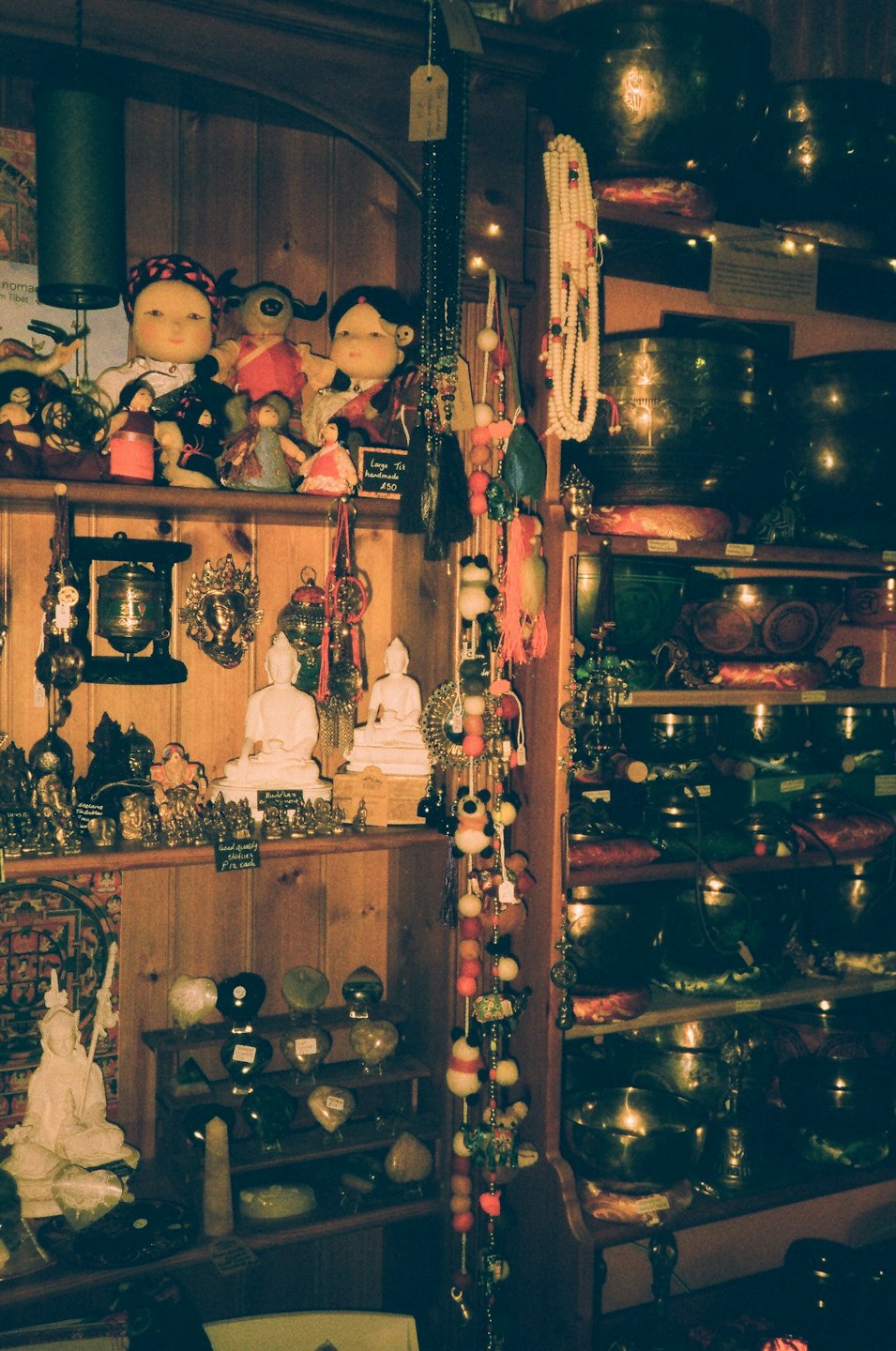 Wooden shelves filled with crystals, statues, and ritual items.